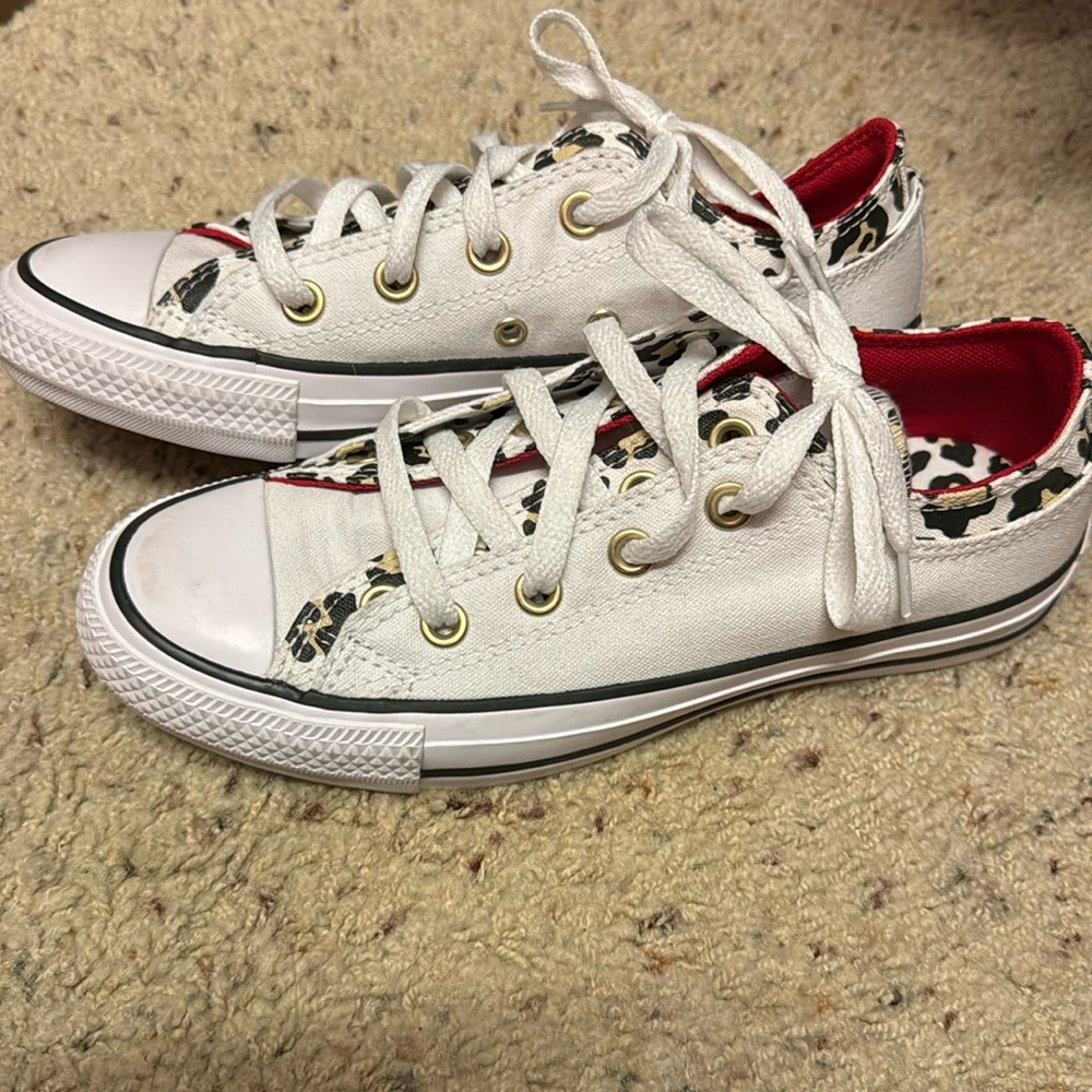 White converse with red and cheetah print details.